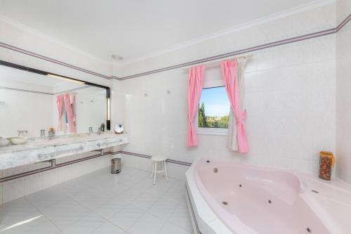a bathroom with a tub and a sink and a mirror at Ca Na Xisca in Sa Coma