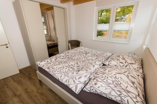 a bedroom with a bed with a comforter and a window at Ferienwohnung Stratmann in Lennestadt