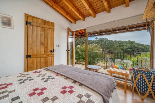 a bedroom with a bed and a sliding glass door at Horta Do Zé Miguel in Monchique