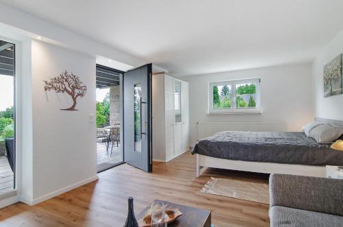 a bedroom with a bed and a living room at Ferienwohnung Gartenblick in Herdwangen-Schönach