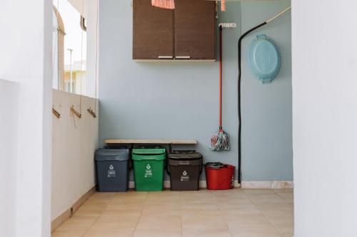 a hallway with four trash cans and a bench in a room at Casa Perla in Villasimius