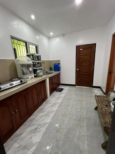 a large kitchen with a counter and a door at Yena's Inn in Cauayan