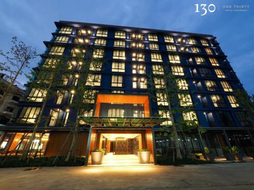a large building with lights in front of it at 130 Hotel & Residence Bangkok in Bangkok