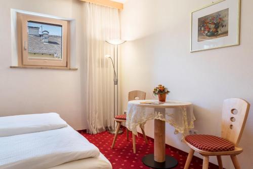 a room with a table and chairs and a bed at Haus Rosengarten Apt A in Terlano