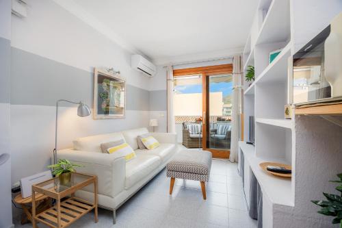 a living room with a white couch and a table at Formentorgloria in Port de Pollensa