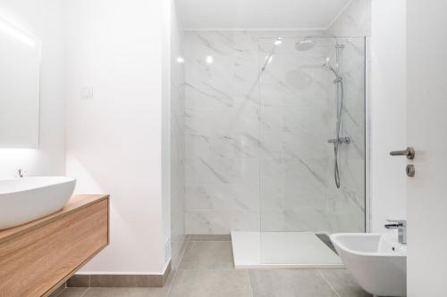 a white bathroom with a shower and a sink at Portimao riverview T2 luxe 1 floor in Portimão