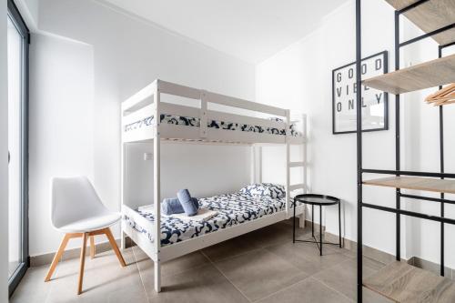 a bedroom with a bunk bed with a chair and a table at Portimao riverview T2 luxe 1 floor in Portimão