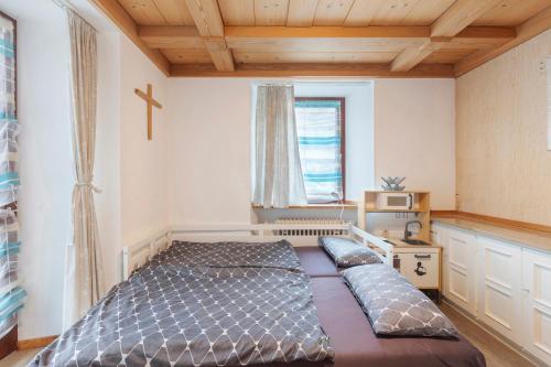 ein großes Bett in einem Zimmer mit einem Kreuz an der Wand in der Unterkunft Zur Ankegass in Görwihl