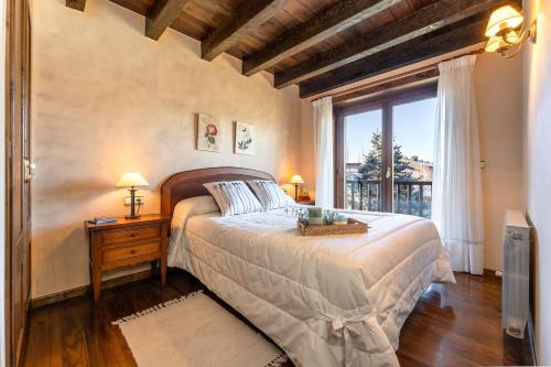 a bedroom with a large bed and a window at Casa Fontanals de Cerdanya in Soriguerola