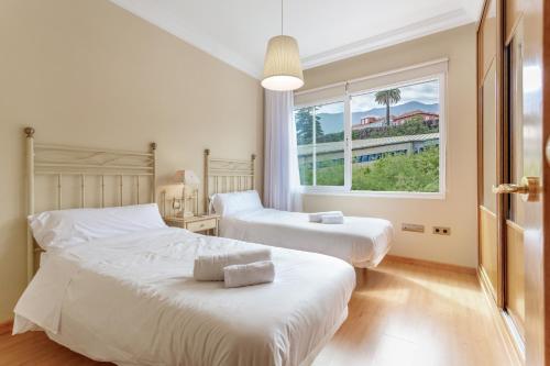 two beds in a bedroom with a large window at Villa Teide in La Orotava