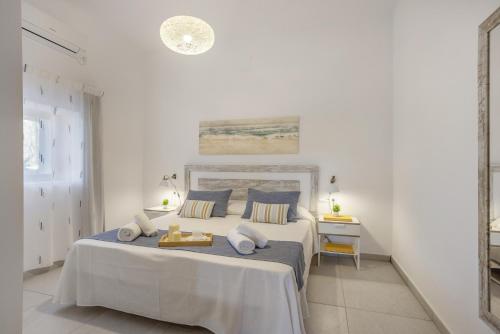 a white bedroom with a large bed with blue pillows at Ca Ses Celleres in La Mola
