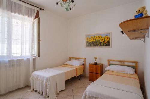 two twin beds in a room with a window at Casa Angel in Galatone