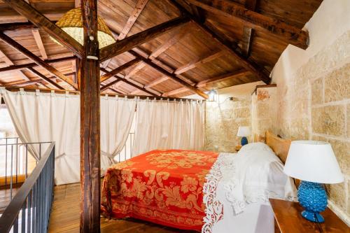 a bedroom with a bed in a room with wooden ceilings at Dimora Pisanelli in Specchia