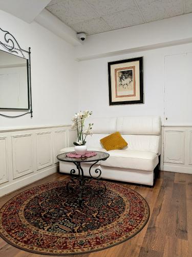 a living room with a white couch and a table at Hotel Wilson Square in Toulouse