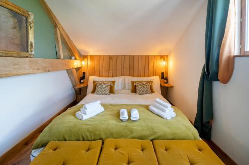 a bedroom with a bed with two white slippers at L'Atelier de Scarlett - Lannux in Lannux