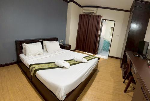 a bedroom with a large bed with white sheets at Emporium Chiangmai in Chiang Mai