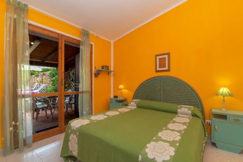 a bedroom with a green bed and a balcony at Rosemary House in Olbia