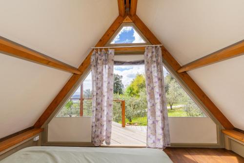 a bedroom with a large window in a roof at Glamping Le Ginestre in Monteverdi Marittimo