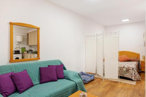 a living room with a green couch and a mirror at Piso tazacorte in Tazacorte