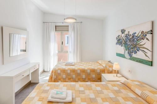 a white bedroom with a bed and a couch at Gemelos in Alcudia