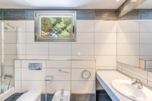 a bathroom with a sink and a tub and a window at Gemelos in Alcudia