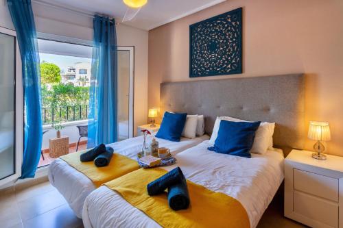 a bedroom with two beds with blue and yellow pillows at Luxury Pool and Spa - Casa Coco in Casas del Cura