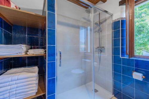 a bathroom with a shower with blue tiles at Las Candelas - Puerto Calderón in Oreña