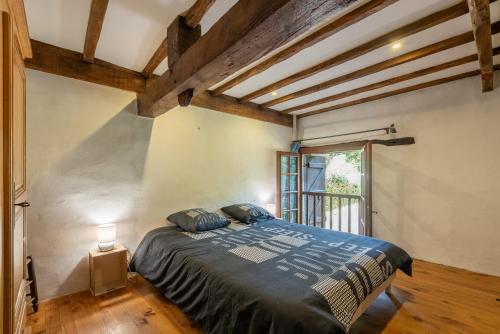 a bedroom with a bed in a room with wooden ceilings at Charmante Bergerie in Castet