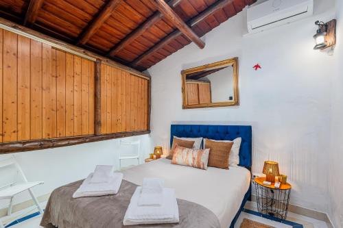 a bedroom with a large bed and a mirror at Descanso Alentejano -Casa d'aldeia in Campinho