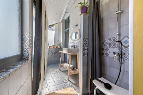 a small bathroom with a sink and a shower at Gîte L'ancien Préau in Avrillé-les-Ponceaux