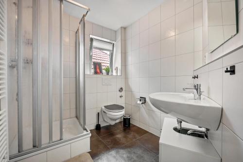 a bathroom with a sink and a toilet and a shower at Altstadtblick Jever in Jever