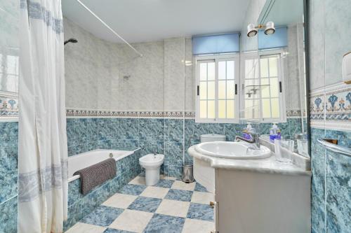 a bathroom with a tub and a toilet and a sink at Casa Alba in Salobreña