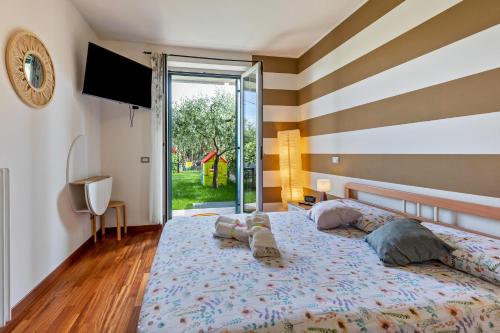 a bedroom with a large bed and a large window at Bluemoon Luminoso apt con piscina in Lazise