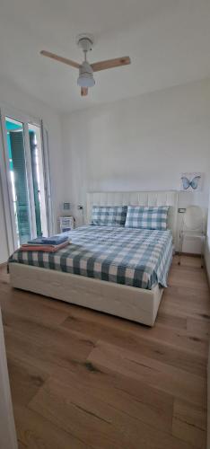 a bedroom with a bed in a room with wooden floors at Villa Su 3 Piani Con Giardino in Lido di Spina