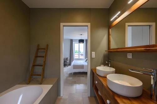 a bathroom with two sinks and a mirror at Domaine le St Georges - Piscine in Saint-Sauveur-le-Vicomte