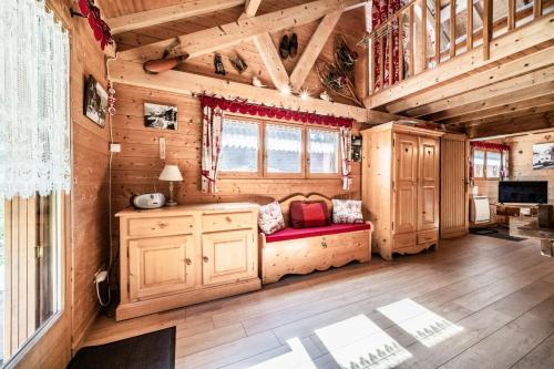 a log cabin with a red couch in a room at Chalet 6p Premium - La Bergeronette in Verchaix