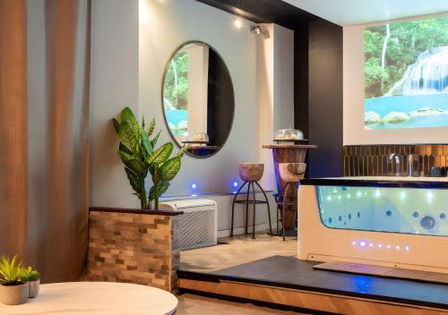 a living room with a tv and a fish tank at Suite toute équipée Jacuzzi privé in Nîmes