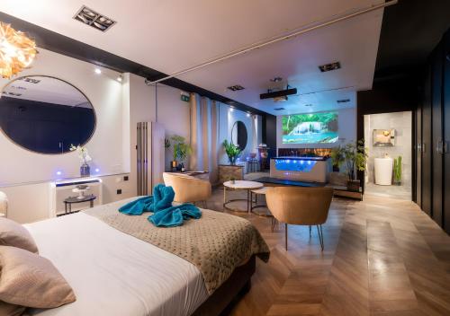 a bedroom with a bed and a living room at Suite toute équipée Jacuzzi privé in Nîmes