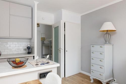 a white kitchen with a desk and a chair at Appart' Chez Suzi, La Baule centre in La Baule