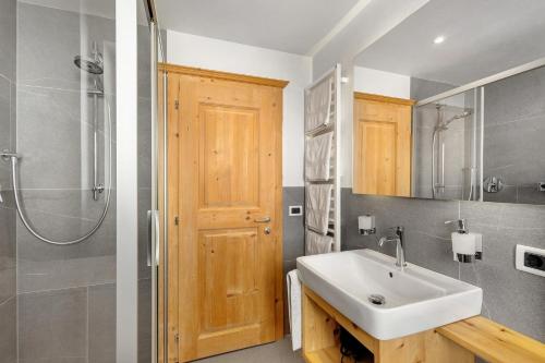 a bathroom with a sink and a shower at Lüch dl Pinter in San Martino in Badia