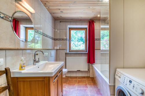 a bathroom with a sink and a washing machine at Maison Orange in Aspiran