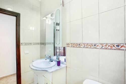 a white bathroom with a sink and a mirror at Villa Palomino in Gáldar