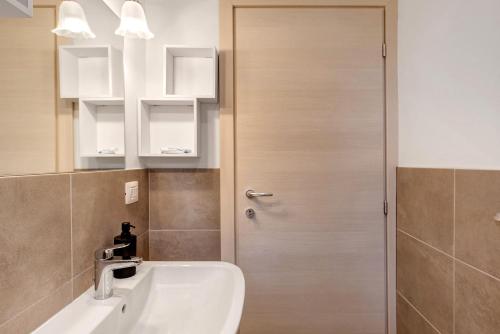 a bathroom with a door next to a sink at La Sosta di Isa in Delebio