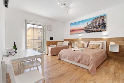 a bedroom with two beds and a table and a desk at Il Centro Luxury Suites in Bari