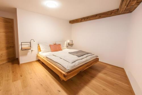 a bedroom with a bed and a wooden floor at Alpenblick De Luxe in Oetz