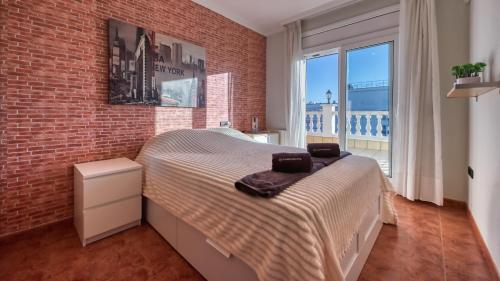 a bedroom with a bed and a brick wall at Costacabana - Villa Summertime in Lloret de Mar