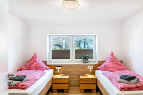 two beds in a room with a window at Landhaus Gerda in Wangerland