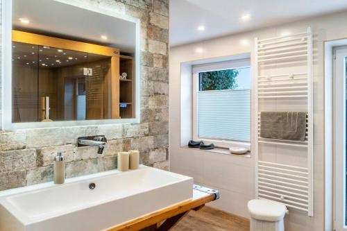 a bathroom with a white sink and a window at Landhaus Gerda in Wangerland