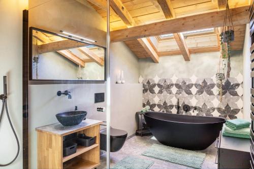 a bathroom with a black tub and a sink at Alpview Loft Garmisch in Garmisch-Partenkirchen