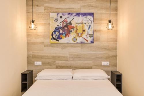a bedroom with a bed and a painting on the wall at Atic Moon Miami in Empuriabrava